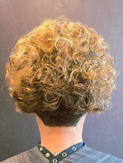 Short, cropped golden-brown curls