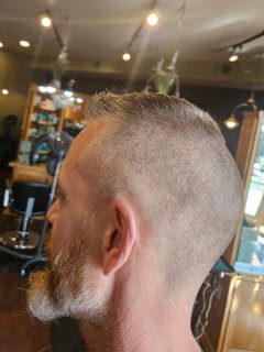 A man's shaved undercut and beard, cut in the salon chair
