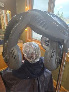 A hooded dryer over a foil set during a colour service