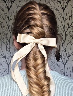 A braided upstyle finished with a ribbon bow